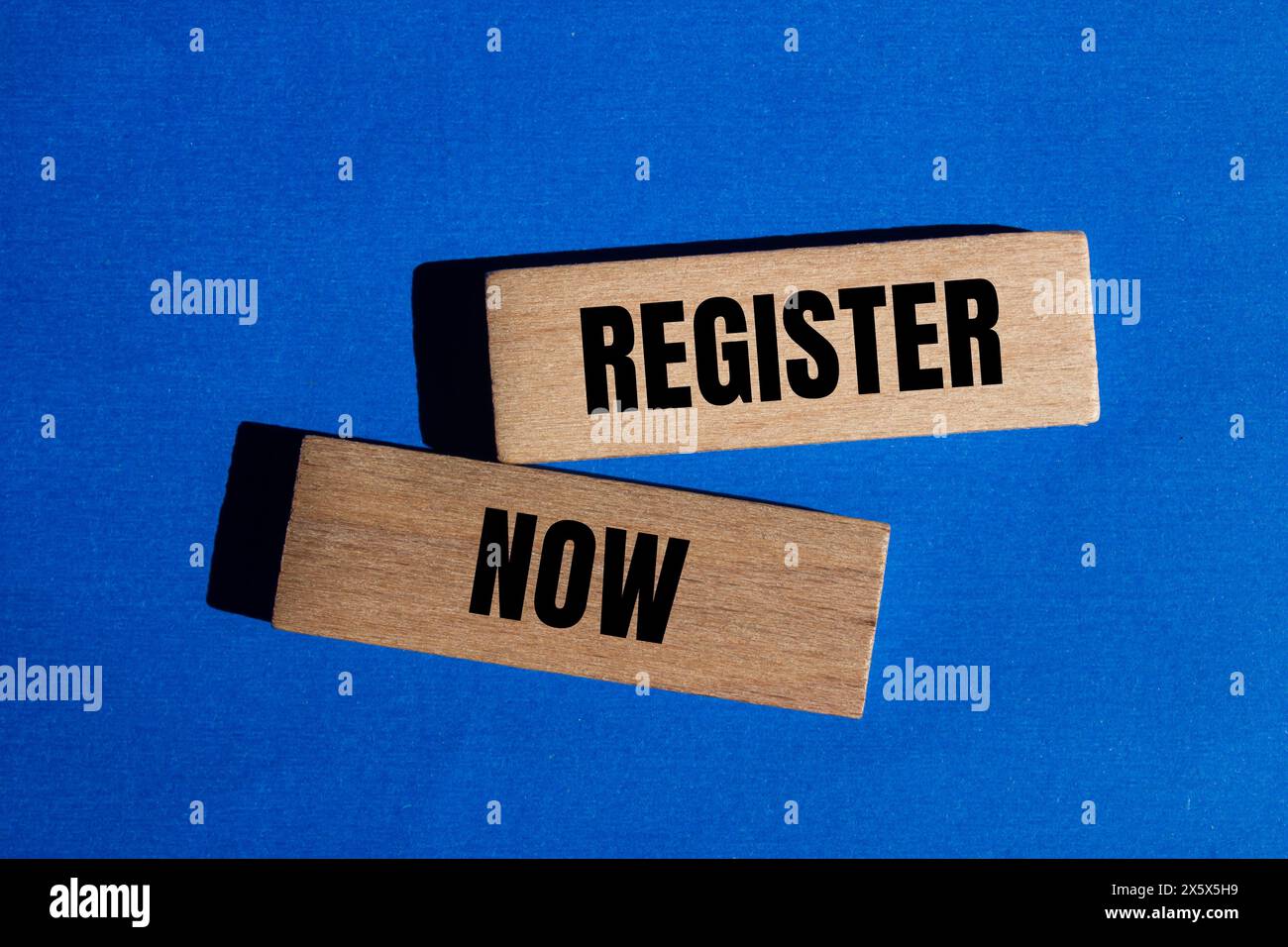 Registra ora le parole scritte su blocchi di legno con sfondo blu. Simbolo del registro concettuale. Copia spazio. Foto Stock