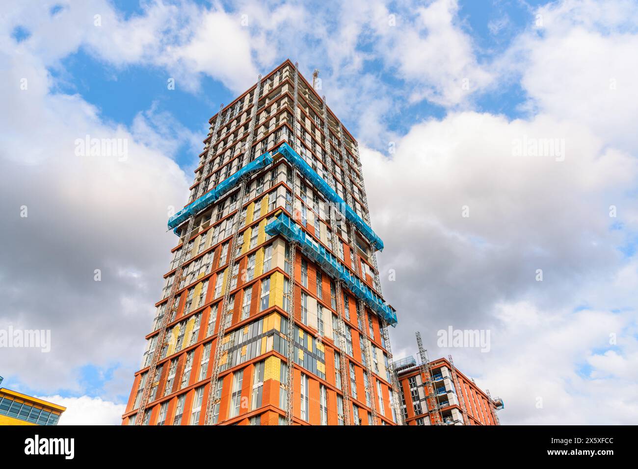 Vista ad angolo basso di una torre residenziale in fase di costruzione in una soleggiata giornata estiva Foto Stock
