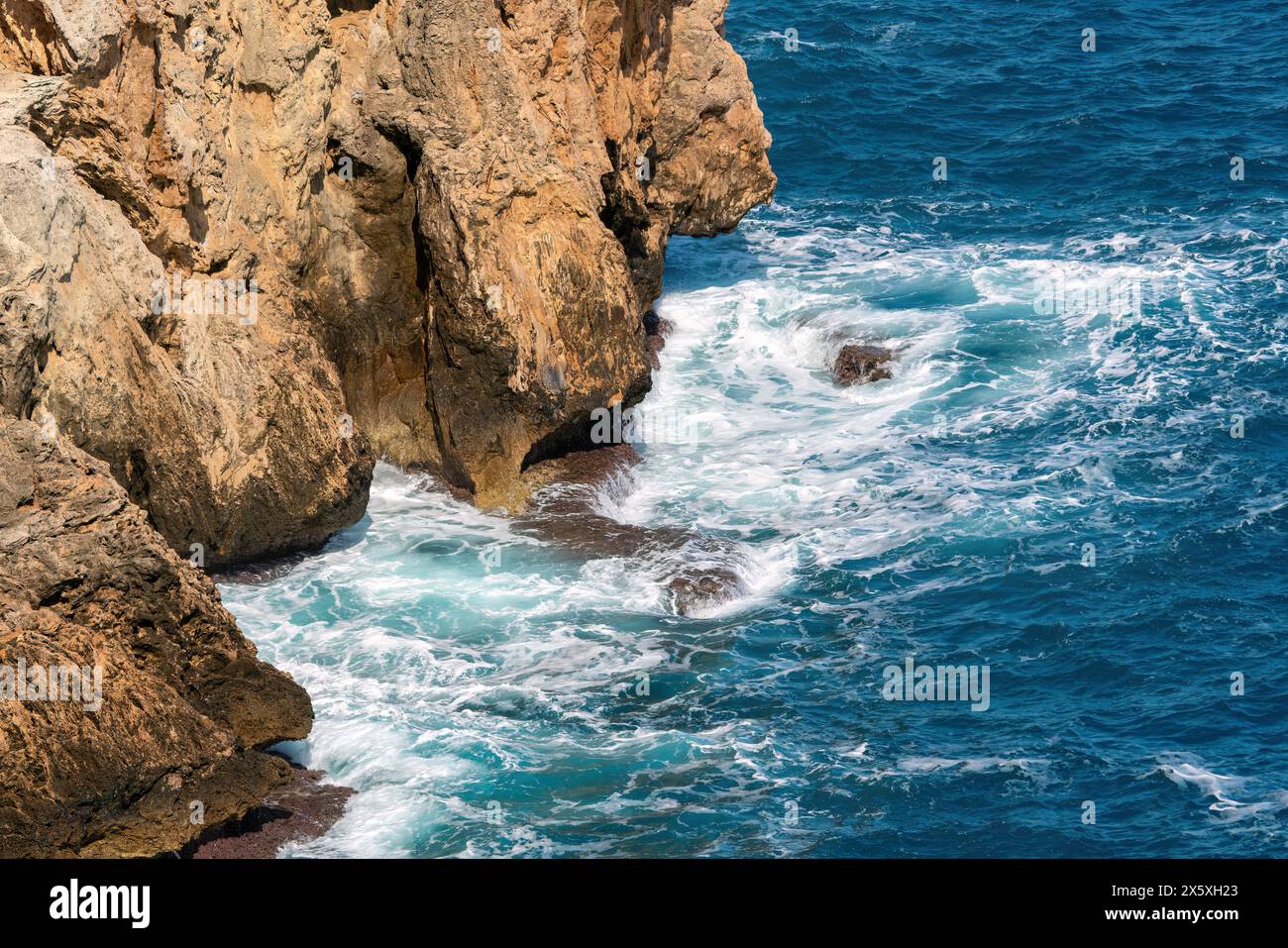 Onde di un mare blu profondo che si infrangono contro le rocce di Antalya in Turchia Foto Stock