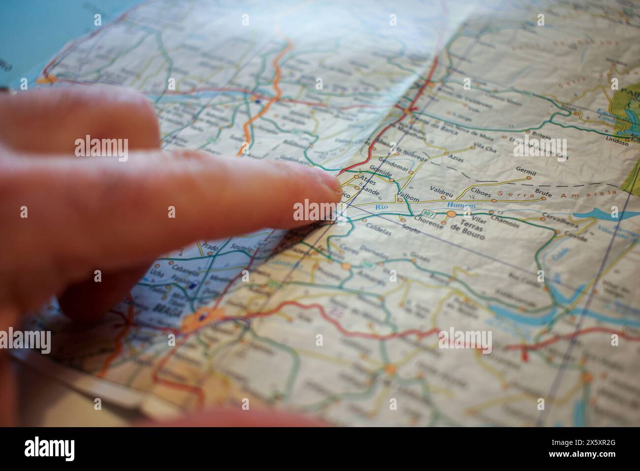 un dito maschile in una mappa stradale per pianificare un viaggio Foto Stock