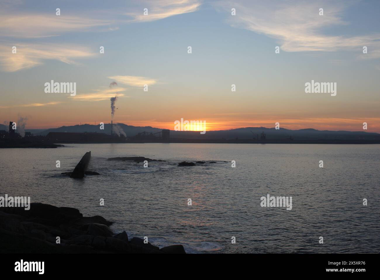 Luci al tramonto di fronte a una fabbrica di alluminio a San Cibrao, Spagna Foto Stock