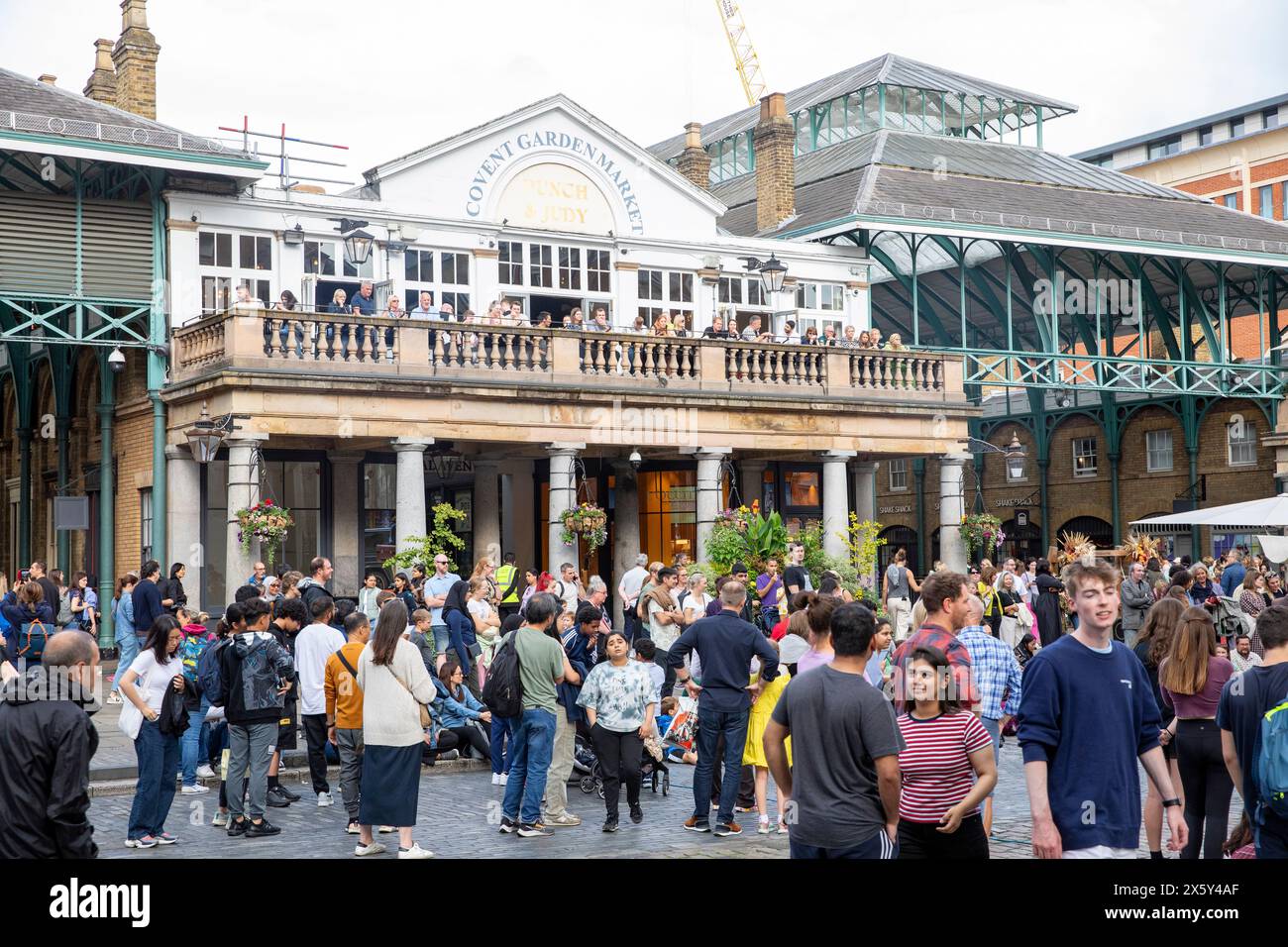 Covent Garden piazza Londra , i giovani si mescolano sulla piazza acciottolata accanto al mercato di Covery Garden e al pub Punch & Judy, Inghilterra, Regno Unito, 2023 Foto Stock