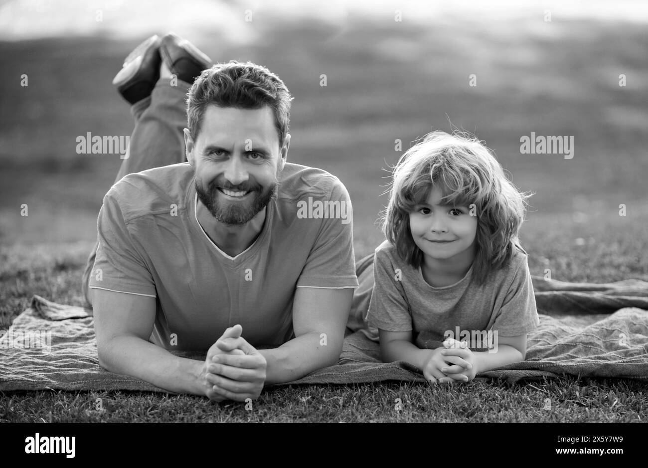 Padre e figlio si rilassano nella natura nel parco. Concetto di bambini e genitori, famiglia felice. Foto Stock