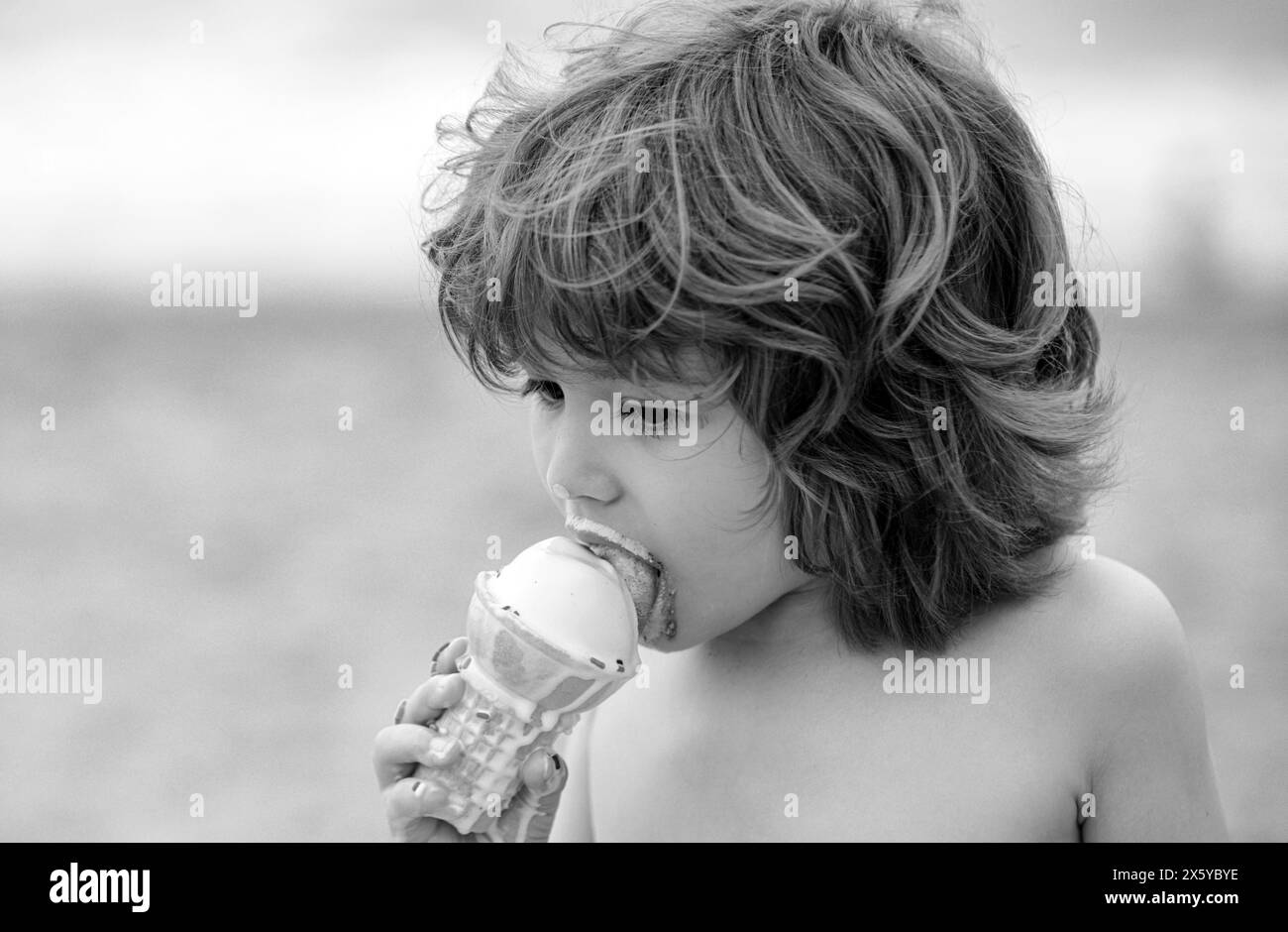 Capretto con faccia sporca che mangia il gelato. Foto Stock