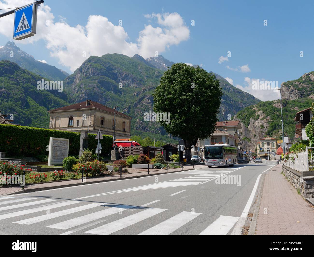 Città di Donnas circondata da montagne con fermata dell'autobus e stazione ferroviaria a sinistra e scuola sullo sfondo in Valle d'Aosta, NW Itay. 11 maggio 2024 Foto Stock