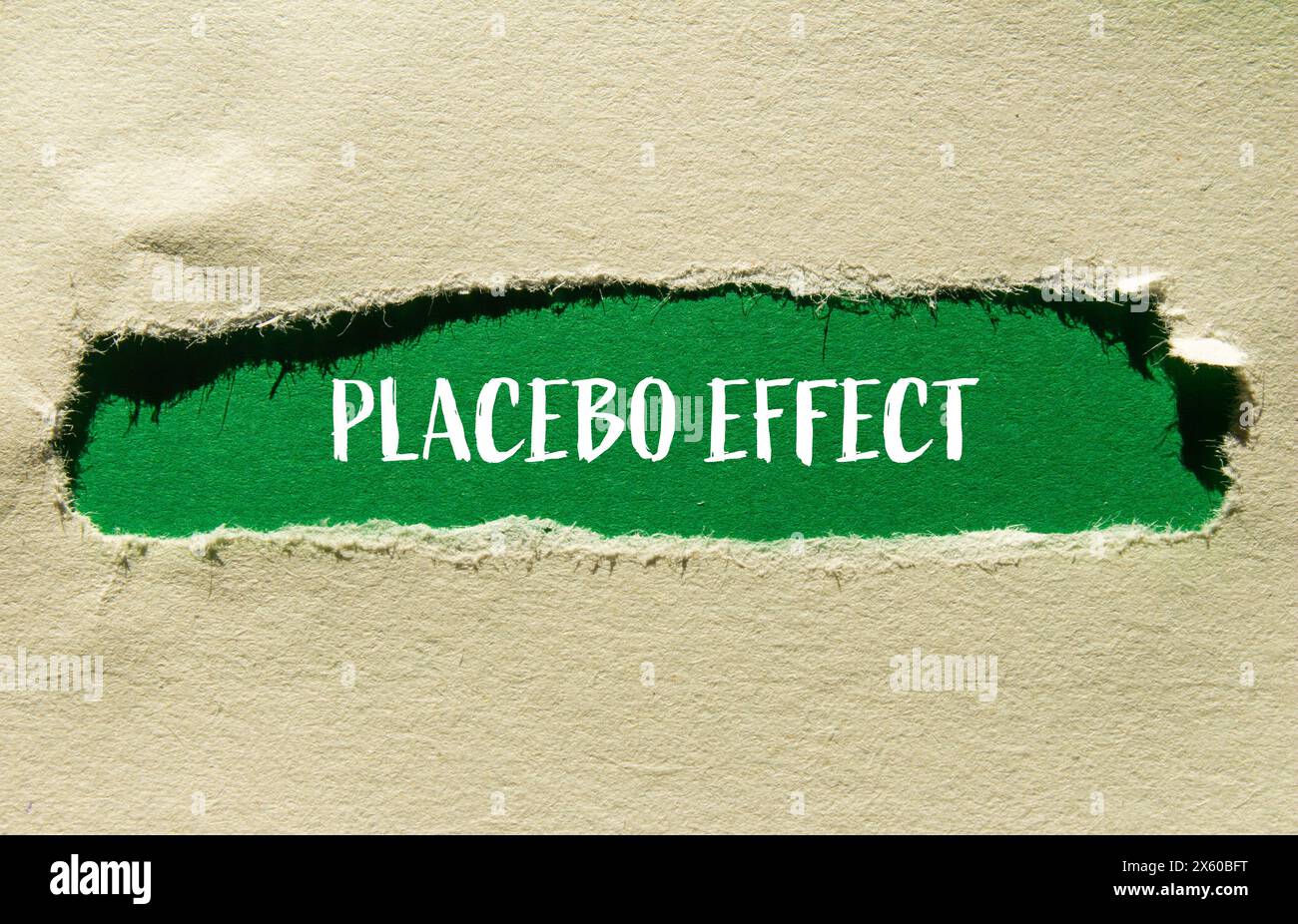 Parole con effetto placebo scritte su carta strappata con sfondo verde. Simbolo concettuale dell'effetto placebo. Copia spazio. Foto Stock