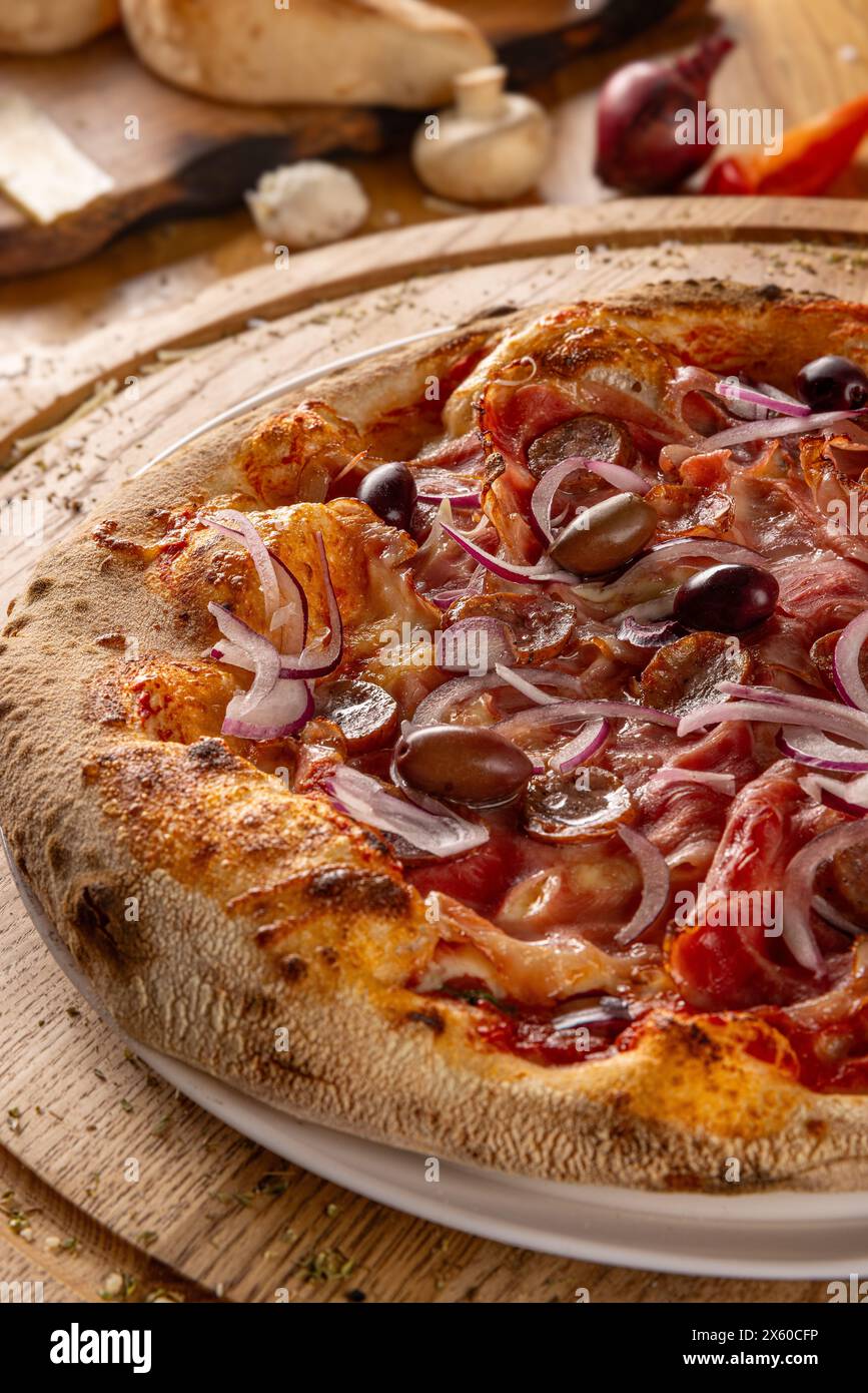 Pizza artigianale cotta a legna su un tavolo rustico, primo piano Foto Stock