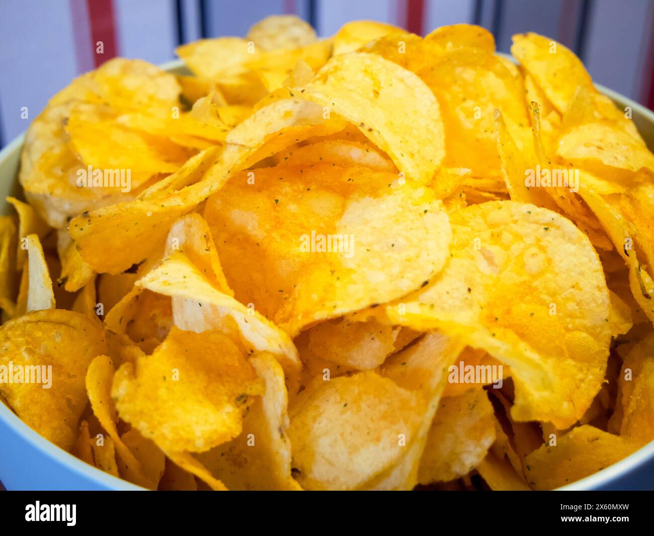 Ora dello spuntino. Patatine fritte in una ciotola blu, ideali per cene informali. Foto Stock