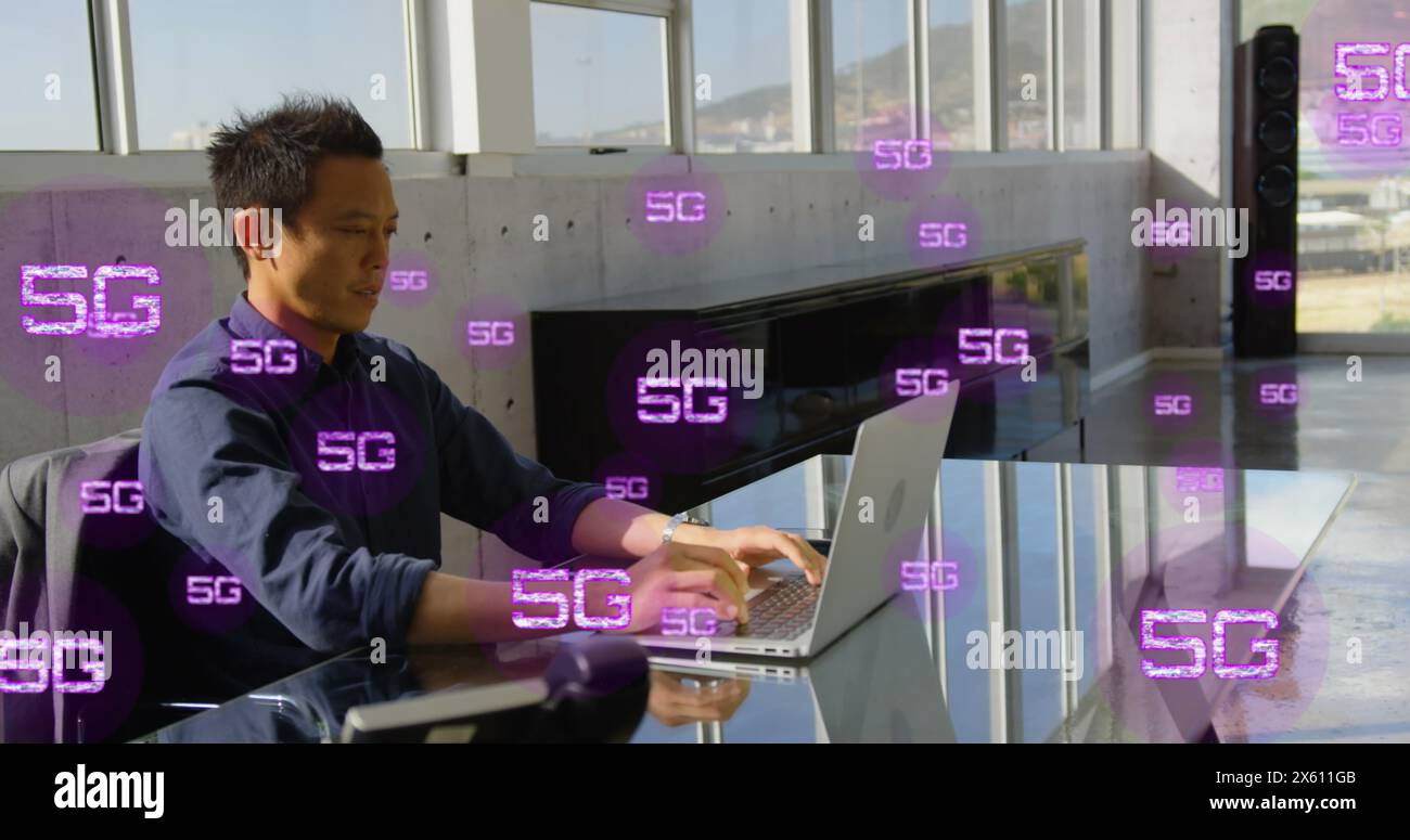 Immagine di più testi 5g su un uomo asiatico seduto su una sedia e che lavora su un computer portatile in ufficio Foto Stock