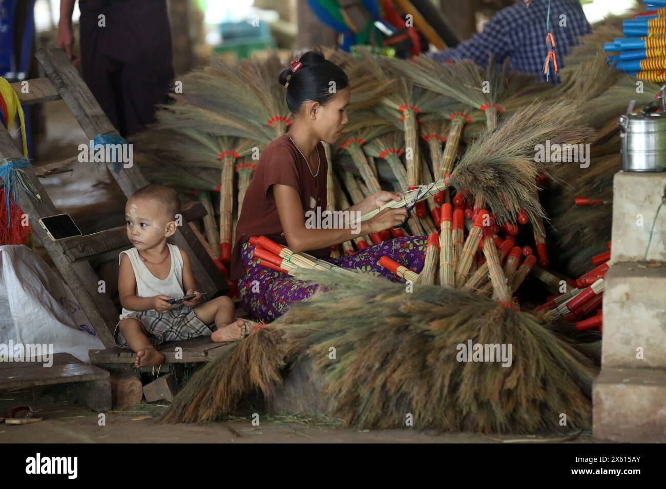 Yangon, Myanmar. 11 maggio 2024. Un abitante del villaggio fa le scope in erba in un laboratorio a Hmawbi Township della regione di Yangon, Myanmar, 11 maggio 2024. PER ANDARE CON "Feature: Le tradizionali imprese di ginnastica del Myanmar lottano per la sopravvivenza" crediti: Myo Kyaw Soe/Xinhua/Alamy Live News Foto Stock
