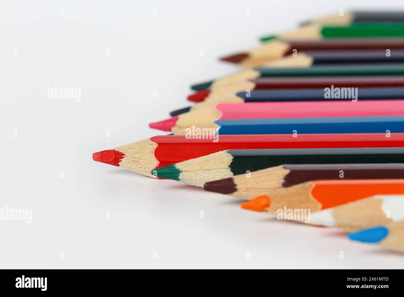 Matite multicolore piegate ad angolo su sfondo bianco. Profondità di campo ridotta Foto Stock