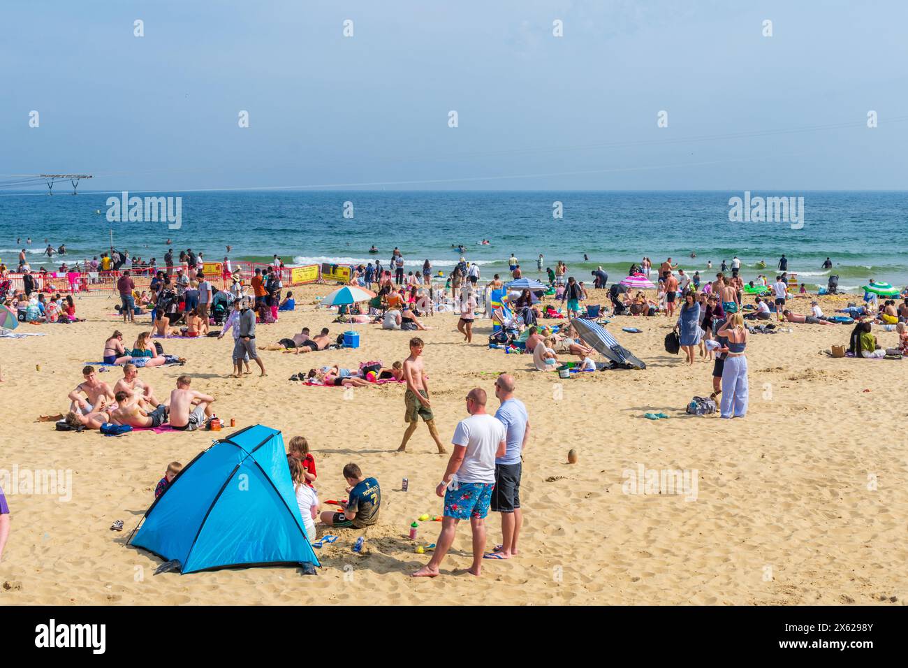 West Cliff Beach, Bournemouth, Regno Unito - 12 maggio 2024: Bagni di sole sulla spiaggia di sabbia. Foto Stock
