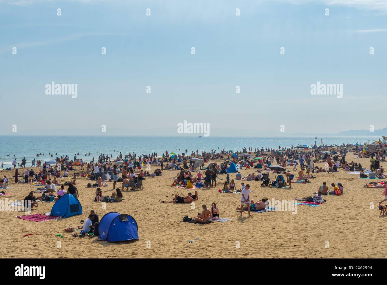 West Cliff Beach, Bournemouth, Regno Unito - 12 maggio 2024: Bagni di sole sulla spiaggia di sabbia. Foto Stock