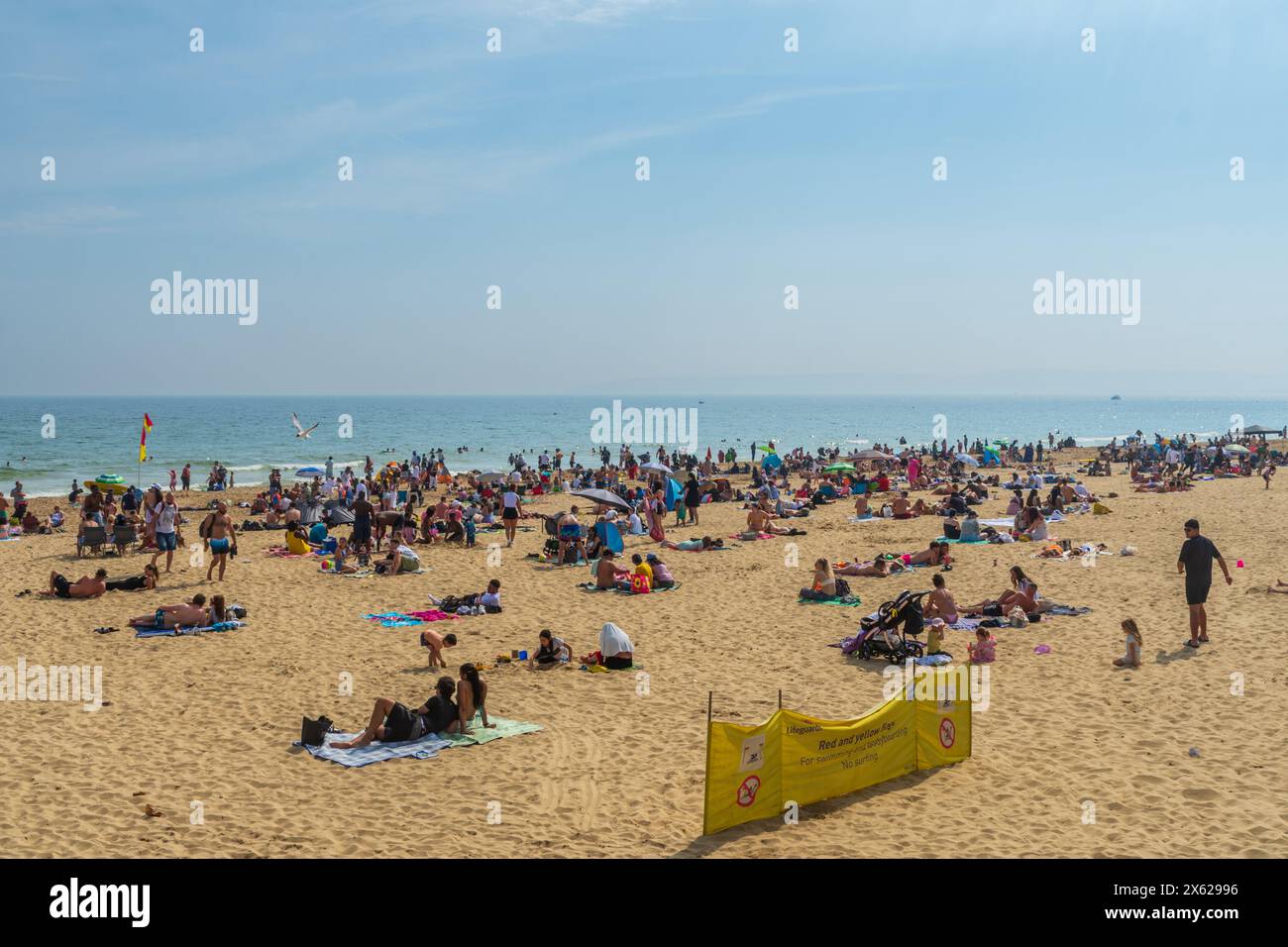 West Cliff Beach, Bournemouth, Regno Unito - 12 maggio 2024: Bagni di sole sulla spiaggia di sabbia. Foto Stock