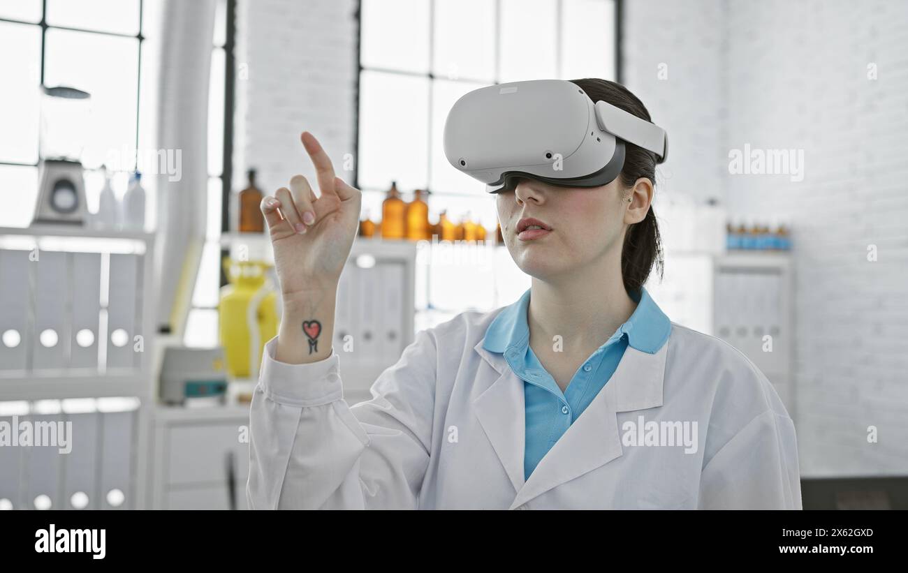 Una giovane donna caucasica indossata in un camice da laboratorio utilizza la tecnologia vr all'interno di un moderno laboratorio. Foto Stock