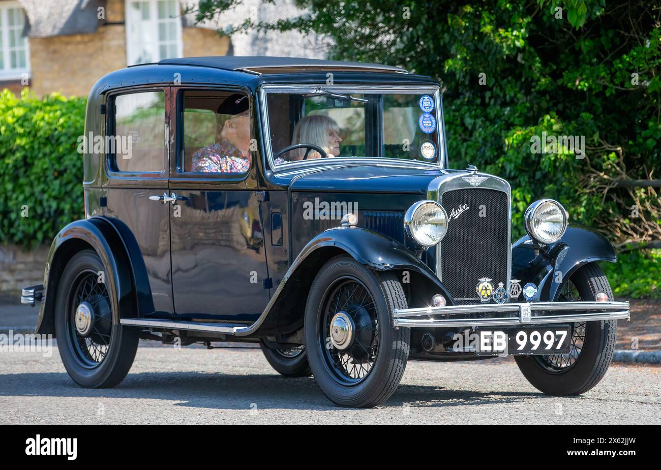 Stoke Goldington, Regno Unito - 12 maggio 2024:1933 Austin auto d'epoca che guida su una strada britannica Foto Stock