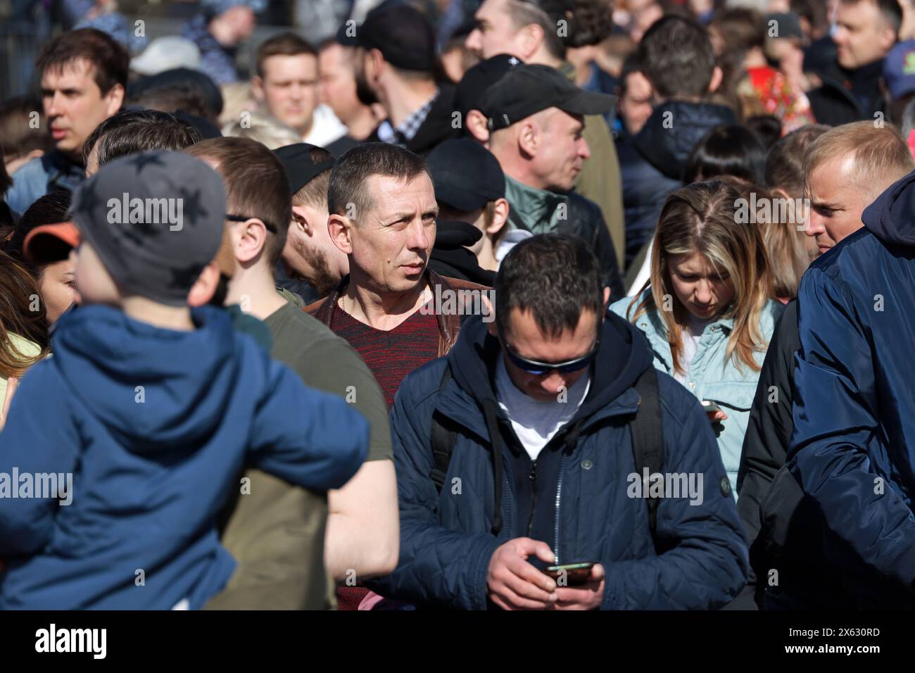 Folla di persone che camminano per una strada, turisti nella città primaverile Foto Stock