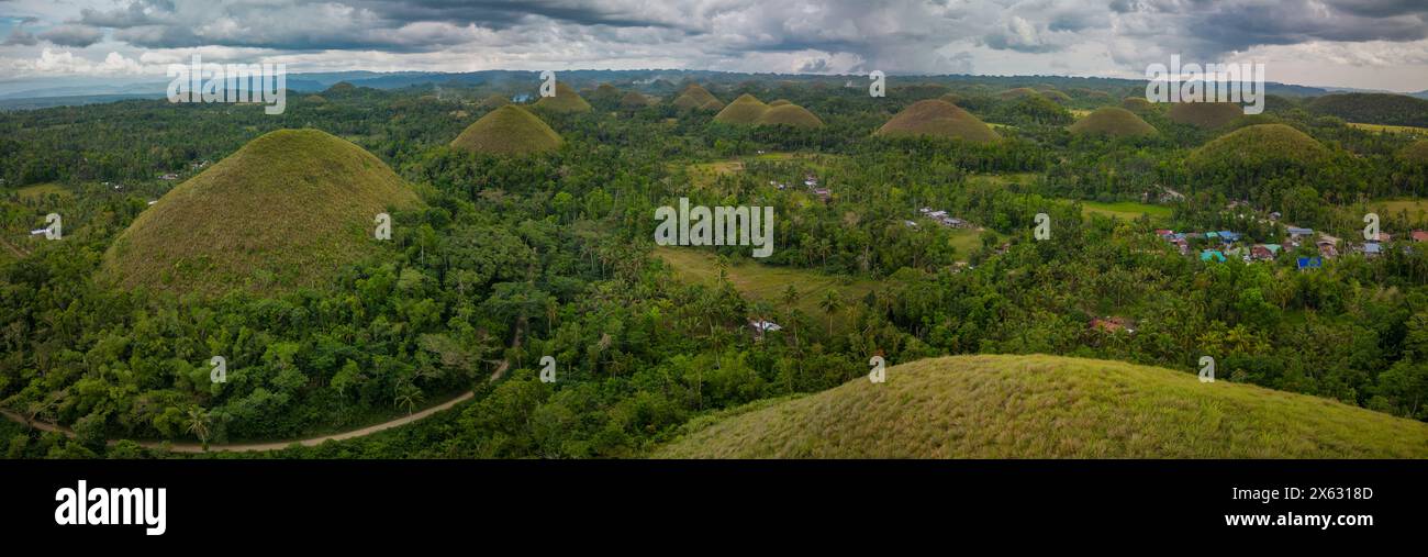 Una vista panoramica delle famose Chocolate Hills a Bohol, Filippine, che mostra le formazioni geologiche naturali a forma di cono tra una vegetazione lussureggiante Foto Stock