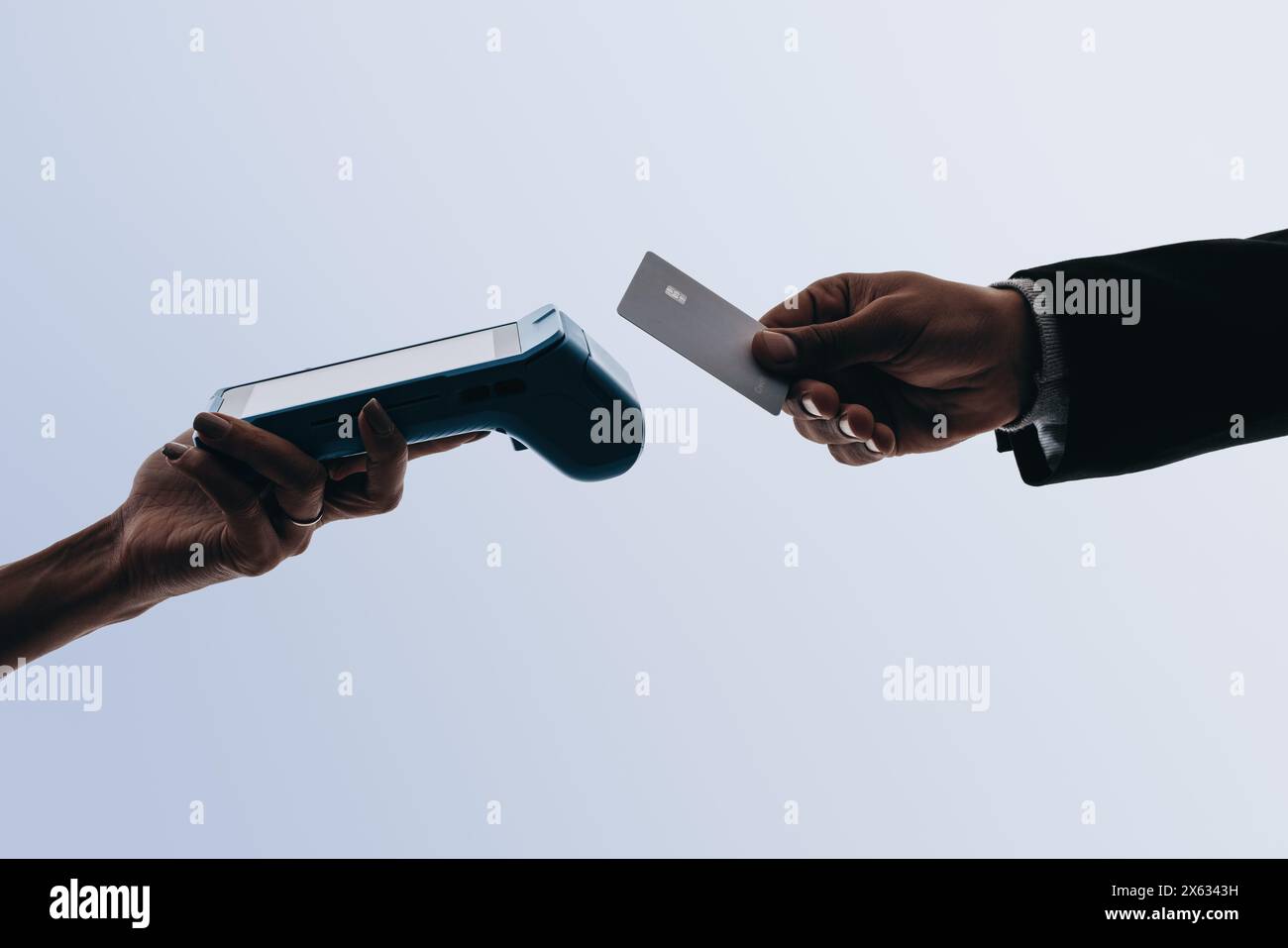 Le mani scansionano una carta bancaria per effettuare il pagamento senza contatto al momento del pagamento. Il lettore elettronico consente transazioni pratiche e senza contanti. Con tecnologia NFC Foto Stock