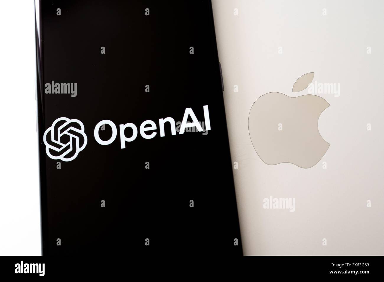 Laptop Apple con smartphone in cima con logo OpenAI. Concetto di tecnologia avanzata e leadership ai. Stafford, Regno Unito, 28 aprile 2024 Foto Stock
