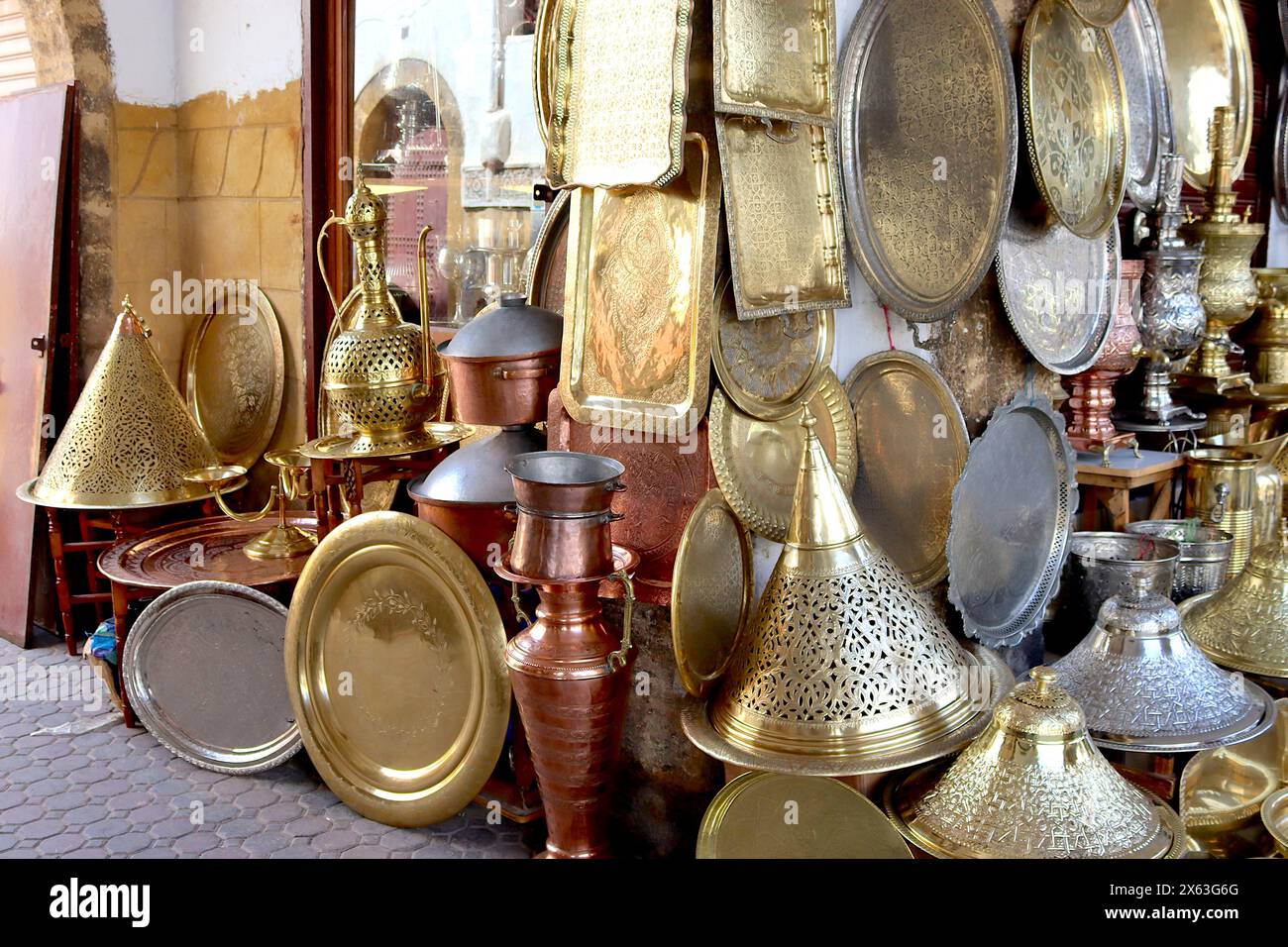 Mercato marocchino che vende oggetti decorati in ottone, rame e argento; vassoi, piatti, teiere, piatti, piatti, lampade da tavolo, lampade da terra Layla. Foto Stock