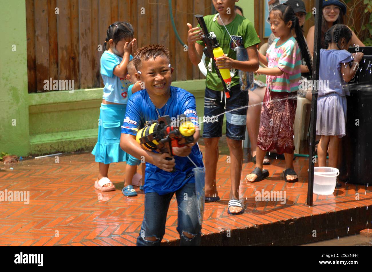 Ragazzo con pistola ad acqua alla parata di Pi mai come parte delle celebrazioni di Capodanno a Luang Prabang, Laos, Foto Stock