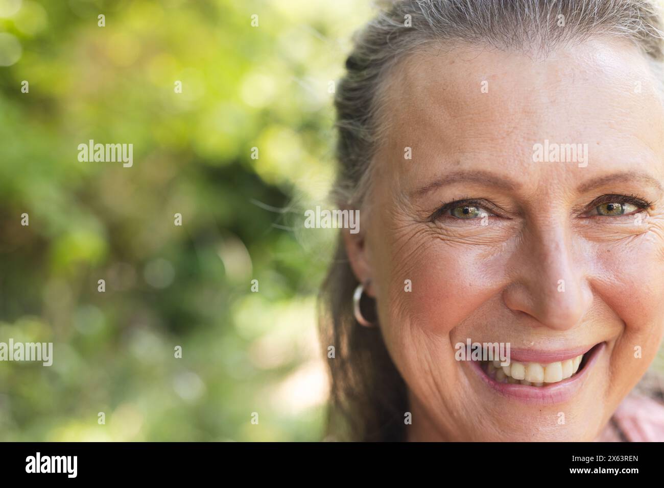 Una donna caucasica anziana che si diverte all'aperto, sfoggiando le sue linee sorridenti, copiando spazio Foto Stock