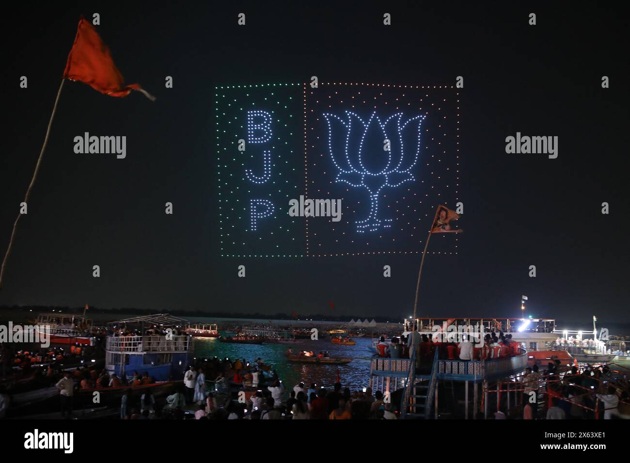 Varanasi, Uttar Pradesh, India. 12 maggio 2024. Le persone scattano foto e registrano video di uno sciame di droni con luci che formano il logo del Bharatiya Janata Party (BJP) a Dashashwamedh Ghat. (Credit Image: © Prabhat Mehrotra/SOPA Images via ZUMA Press Wire) SOLO PER USO EDITORIALE! Non per USO commerciale! Foto Stock
