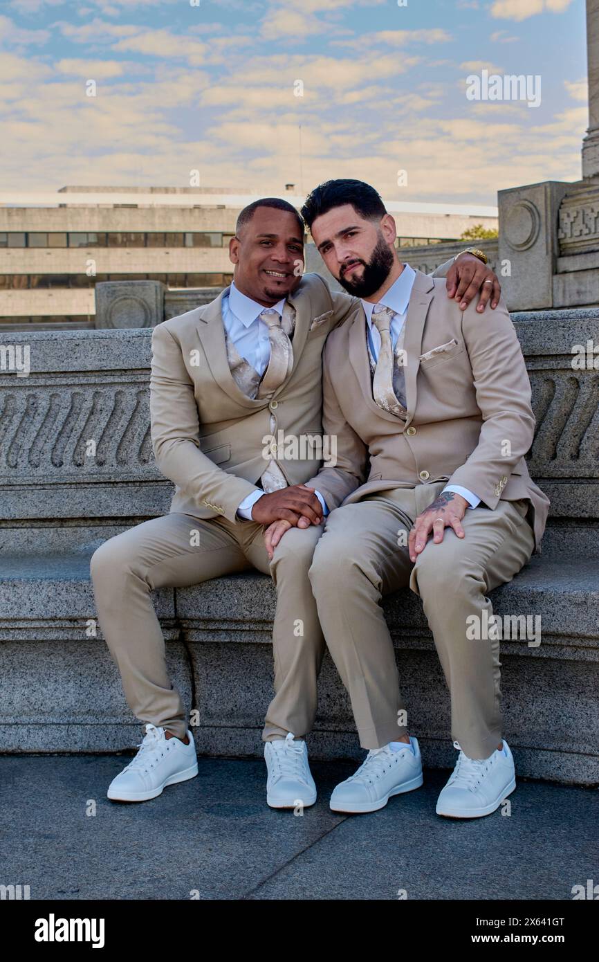 Due ragazzi che si tengono per mano per celebrare il loro amore. Sono sposati, sorridono alla telecamera, orgoglio della comunità LGBT. Foto Stock