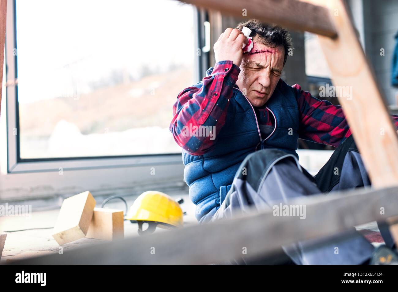 Lavoratore ferito con ferita alla testa, lesioni alla testa. Infortunio sul lavoro, infortunio sul posto di lavoro. Foto Stock