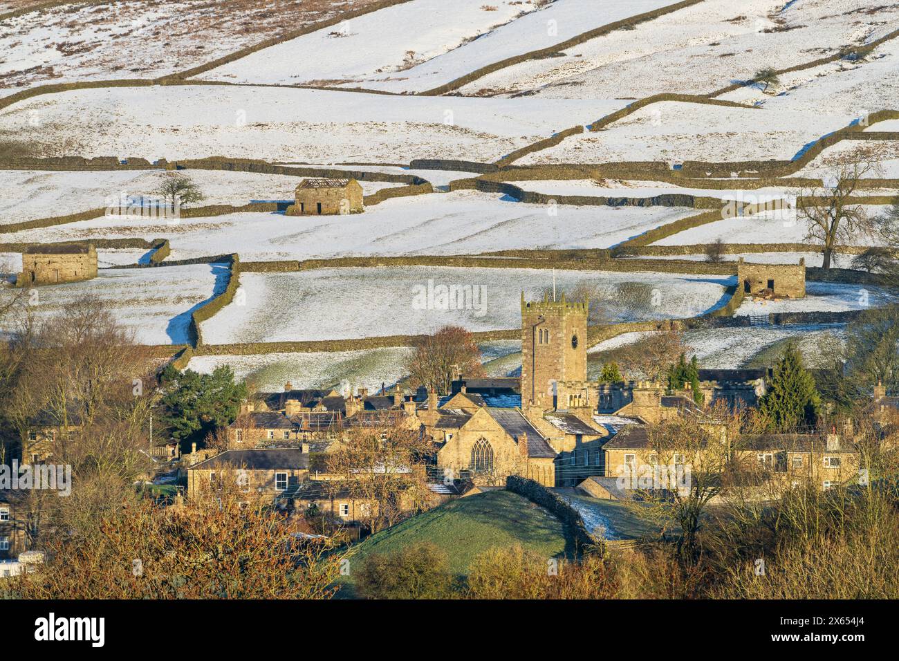 Dales, villaggio di Askrigg nel centro di Wensleydale, con cadute coperte di neve, muretti a secco e fienili. Foto Stock