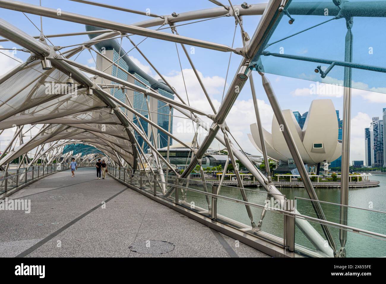 Il complesso in acciaio ritorto del ponte pedonale Helix Bridge con vista sulle spiagge di Marina Bay e sul Museo ArtScience, Marina Bay, Singapore Foto Stock