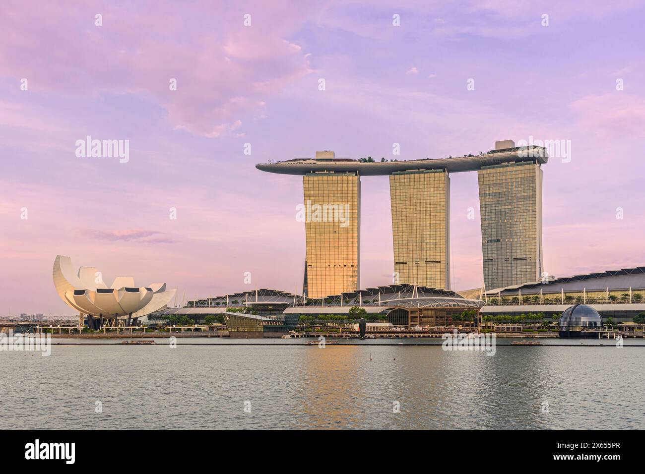 Il Marina Bay Sands Hotel e il Museo ArtScience sono immersi nella luce dorata al tramonto di Marina Bay, Singapore Foto Stock