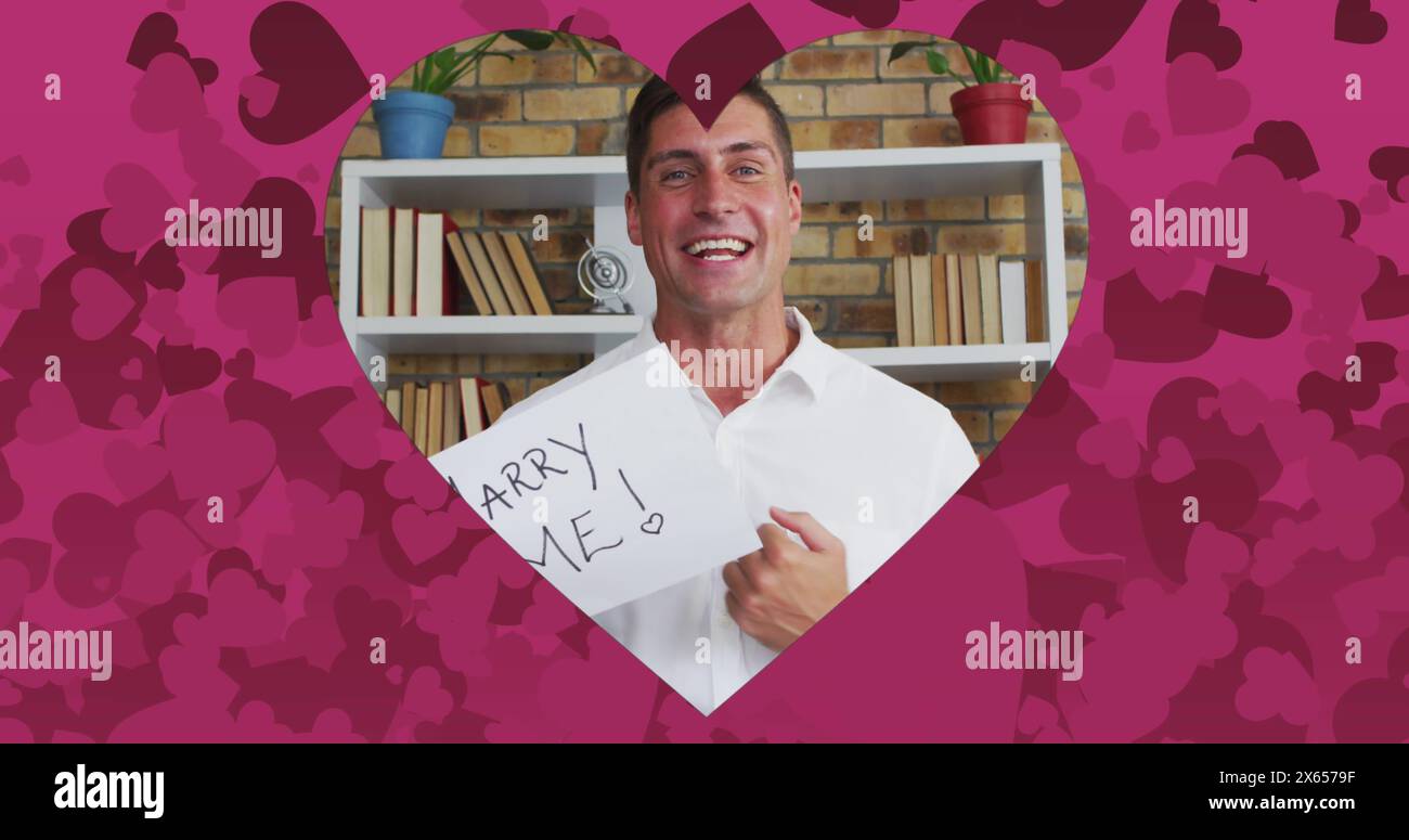 Immagine della cornice a forma di cuore con cuori rosa sopra l'uomo caucasico che propone su chiamata immagine Foto Stock