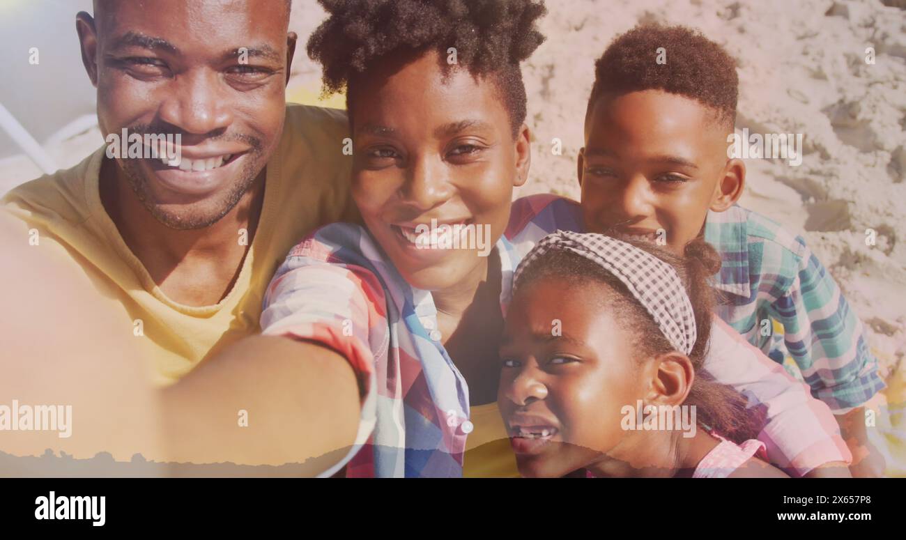 Famiglia afroamericana che si diverte sulla spiaggia, padre che tiene la macchina fotografica Foto Stock