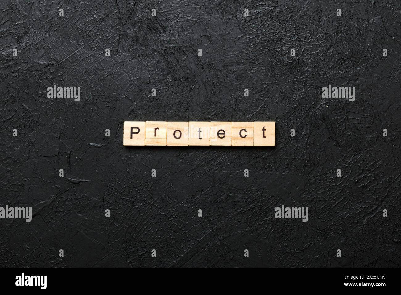 PROTEGGERE la parola scritta sul blocco di legno. PROTEGGA il testo sulla tabella di cemento per il vostro desing, concetto. Foto Stock
