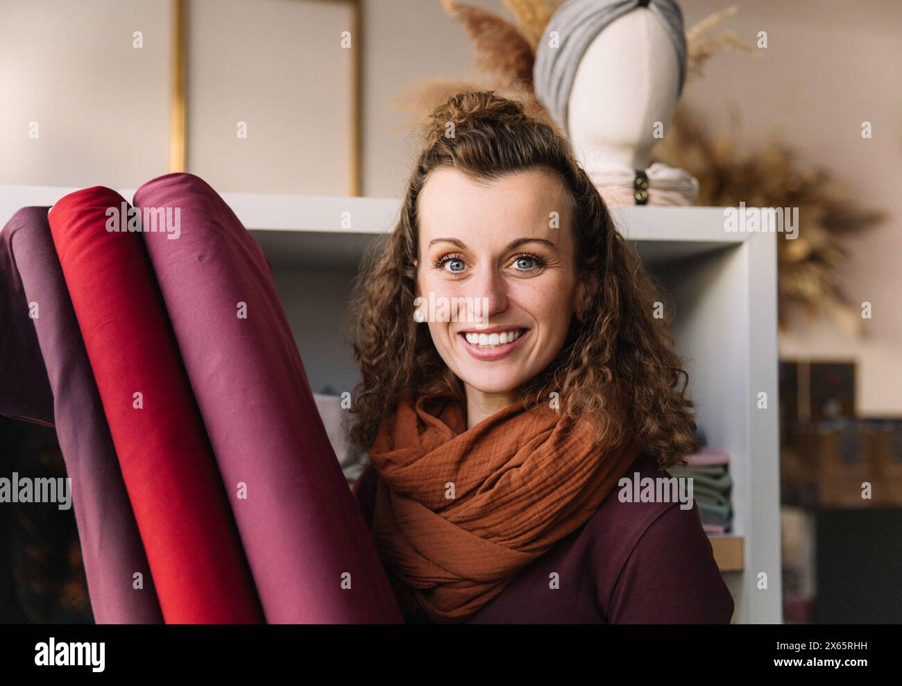 Giovane donna gioiosa con capelli ricci e un sorriso radioso Foto Stock