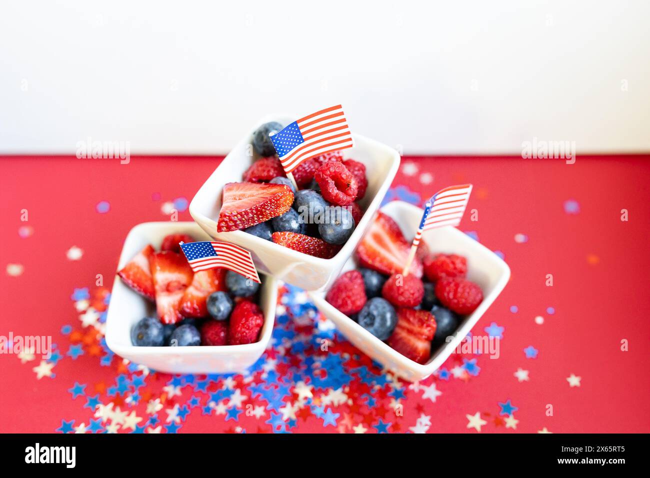 Ciotole di frutta patriottica con frutti di bosco e bandiere americane Foto Stock