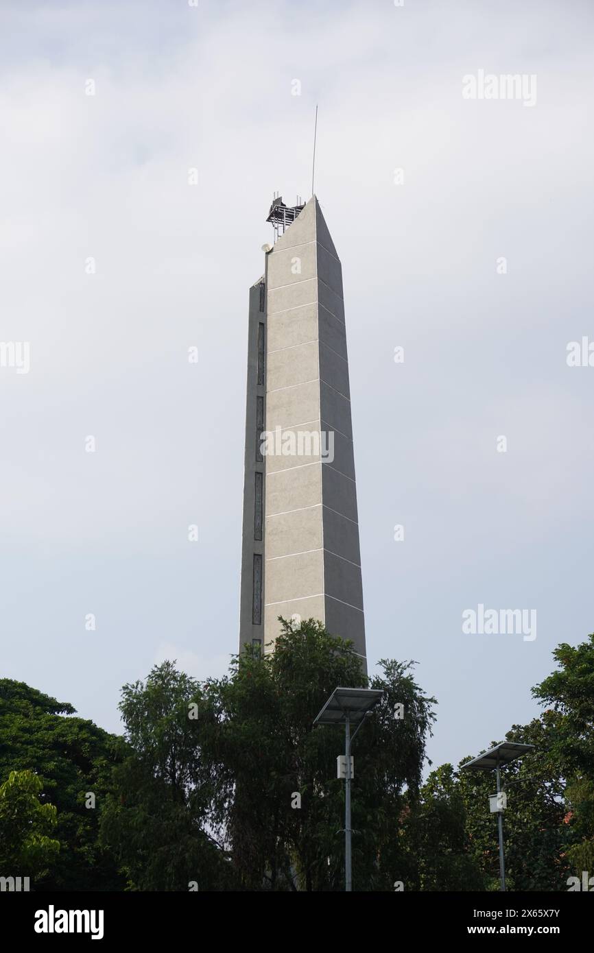 Un'alta torre minimalista con alberi intorno ad essa e un cielo limpido Foto Stock