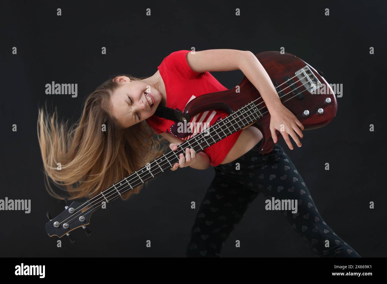 ragazza entusiasta che suona il basso Foto Stock