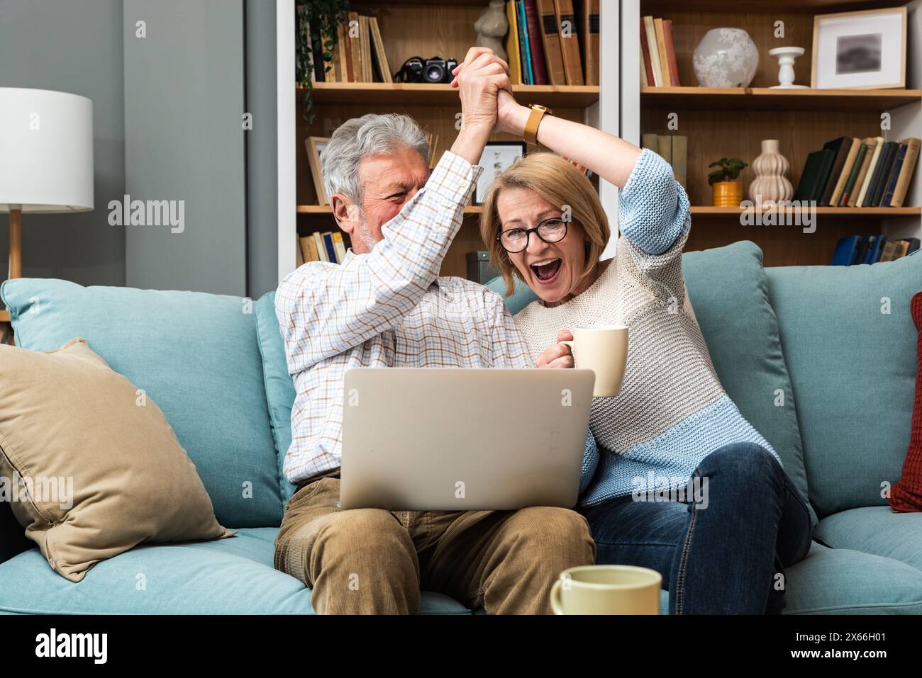 Vita semplice. Una moderna coppia di anziani che usa un computer portatile, cerca su Internet un posto carino per le vacanze. Un anziano pensionato che fa surf Foto Stock