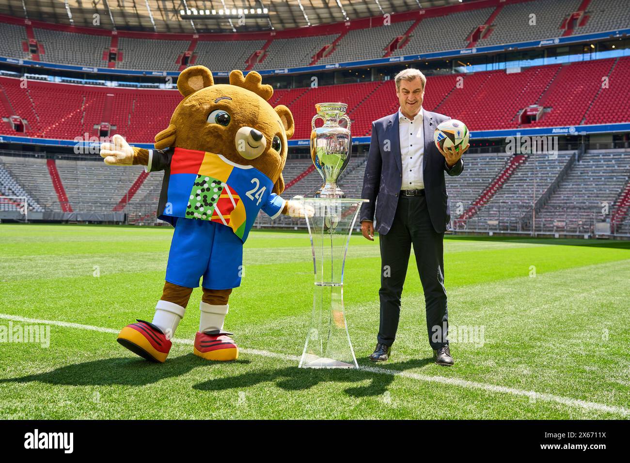 Monaco di Baviera, Germania - 13 maggio 2024: Il primo ministro Dr. Markus Söder CSU sul campo di calcio dell'Allianz Arena di Monaco. Si trova accanto alla Henri Delaunay Cup della UEFA EURO 2024 e detiene un calcio Adidas originale del Campionato europeo di calcio *** Ministerpräsident Dr. Markus Söder CSU auf dem Fußball Spielfeld der Allianz Arena di München. Er steht neben dem Henri-Delaunay-Pokal der UEFA EURO 2024 und hält einen originalen Adidas Fußball der Fußballeuropameisterschaft Foto Stock