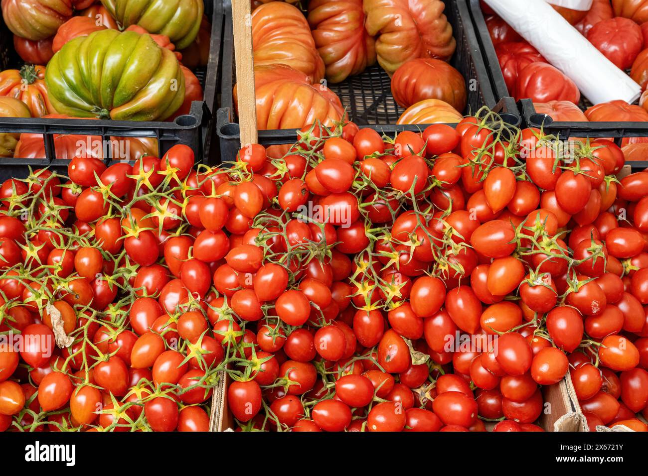 Pomodori piccoli e grandi in vendita in un mercato Foto Stock