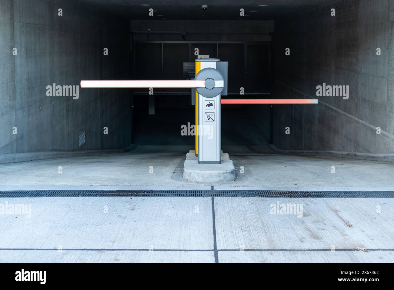 Barriere automatiche all'ingresso dell'area parcheggio. Ingresso al parcheggio sotterraneo. Moderno edificio in cemento. Foto Stock