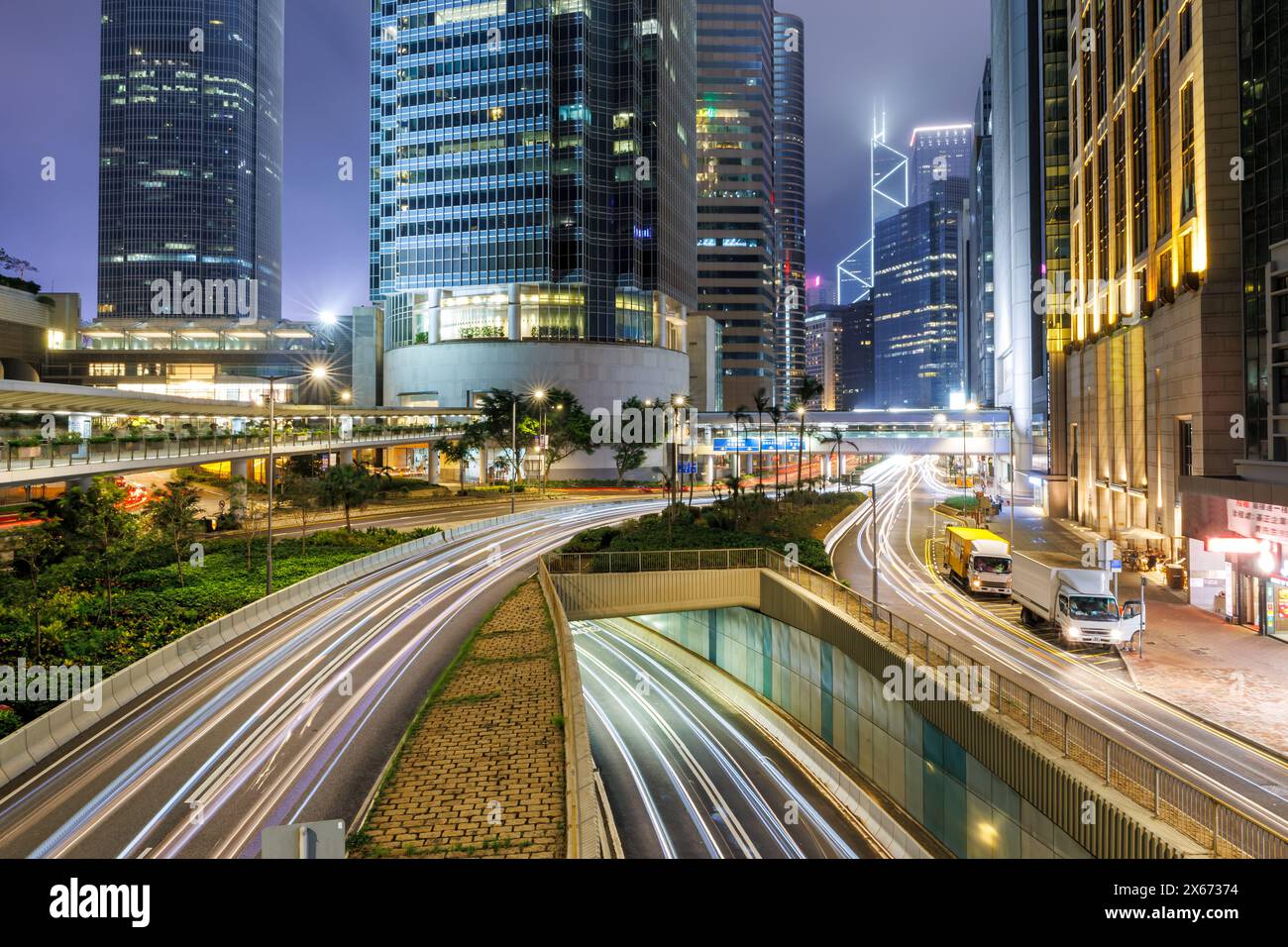 Traffico con strade e grattacieli di notte nella città di Hong Kong, in Cina Foto Stock