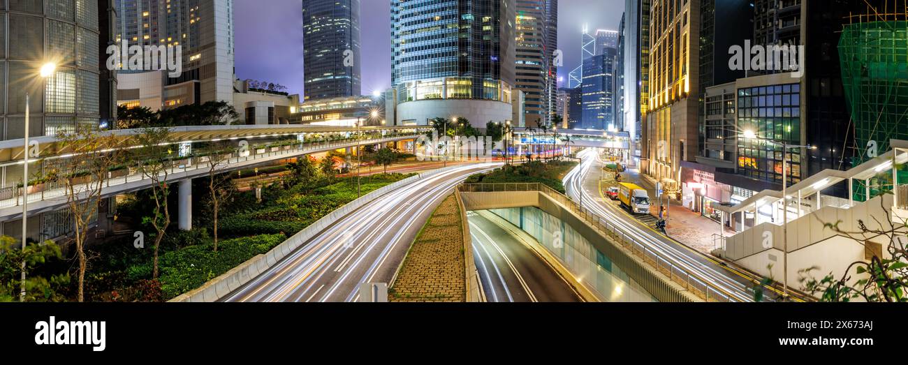Traffico con strade ed edifici grattacieli al panorama notturno nella città di Hong Kong, in Cina Foto Stock