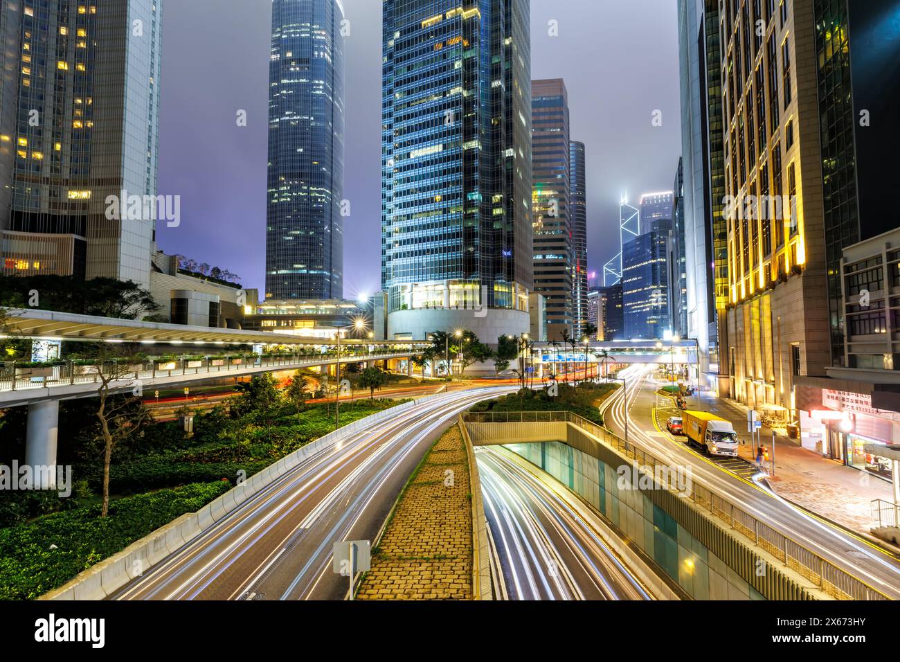 Traffico con strade e grattacieli di notte nella città di Hong Kong, in Cina Foto Stock