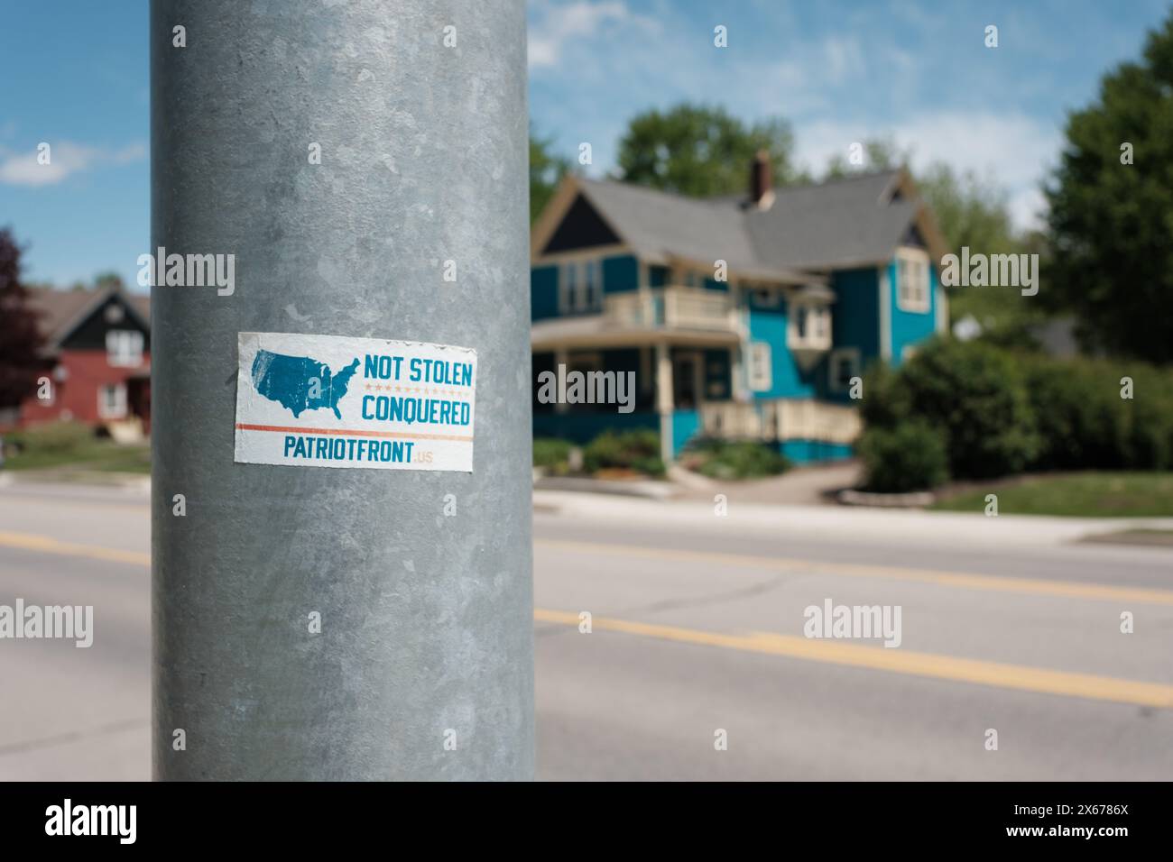 Un adesivo che legge non rubato conquistato, promuovendo il gruppo supremaziale bianco Patriot Front, su un palo a Marlette Michigan USA Foto Stock