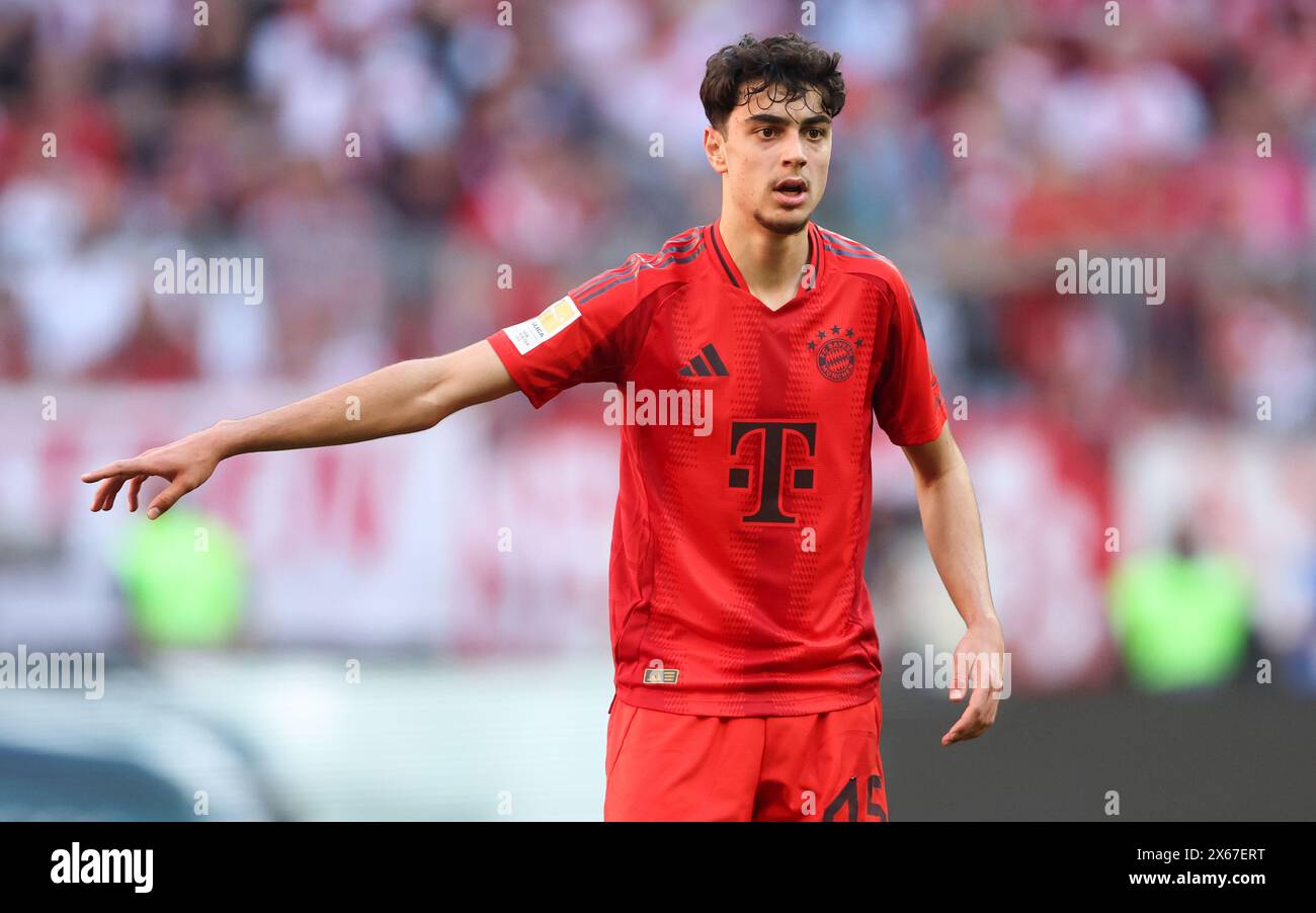 MONACO DI BAVIERA, GERMANIA - 12 MAGGIO: Aleksandar Pavlovic del Bayern Muenchen guarda durante la partita di Bundesliga tra FC Bayern München e VfL Wolfsburg all'Allianz Arena il 12 maggio 2024 a Monaco di Baviera, Germania. © diebilderwelt / Alamy Stock Foto Stock