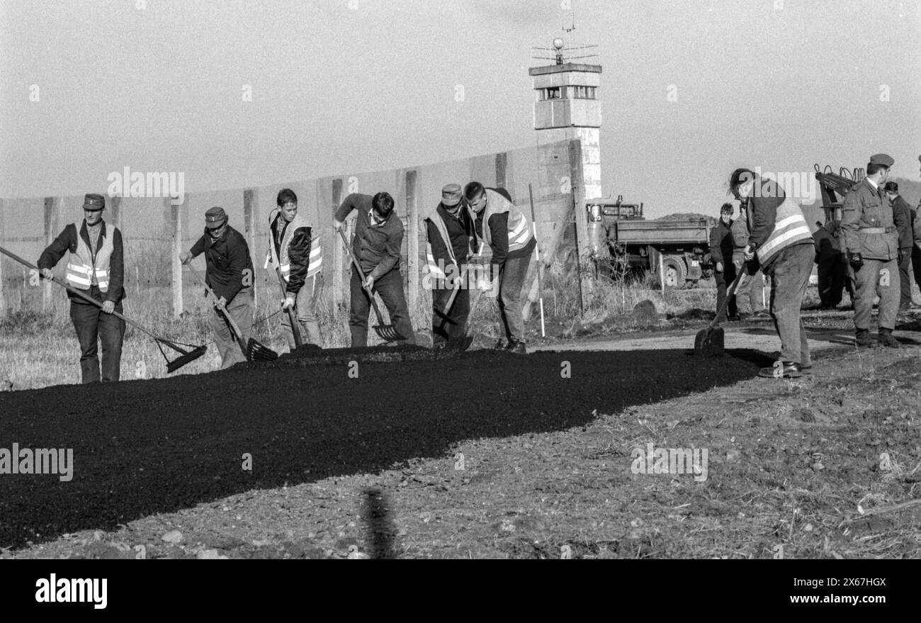 Apertura del confine con la RDT, i lavoratori edili aprono la recinzione di confine e asfaltano una strada di accesso Foto Stock